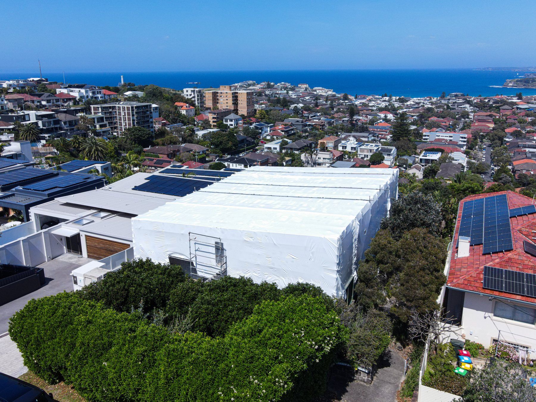 The white shrink wrap among the Dover Heights houses, the coastline and ocean behind