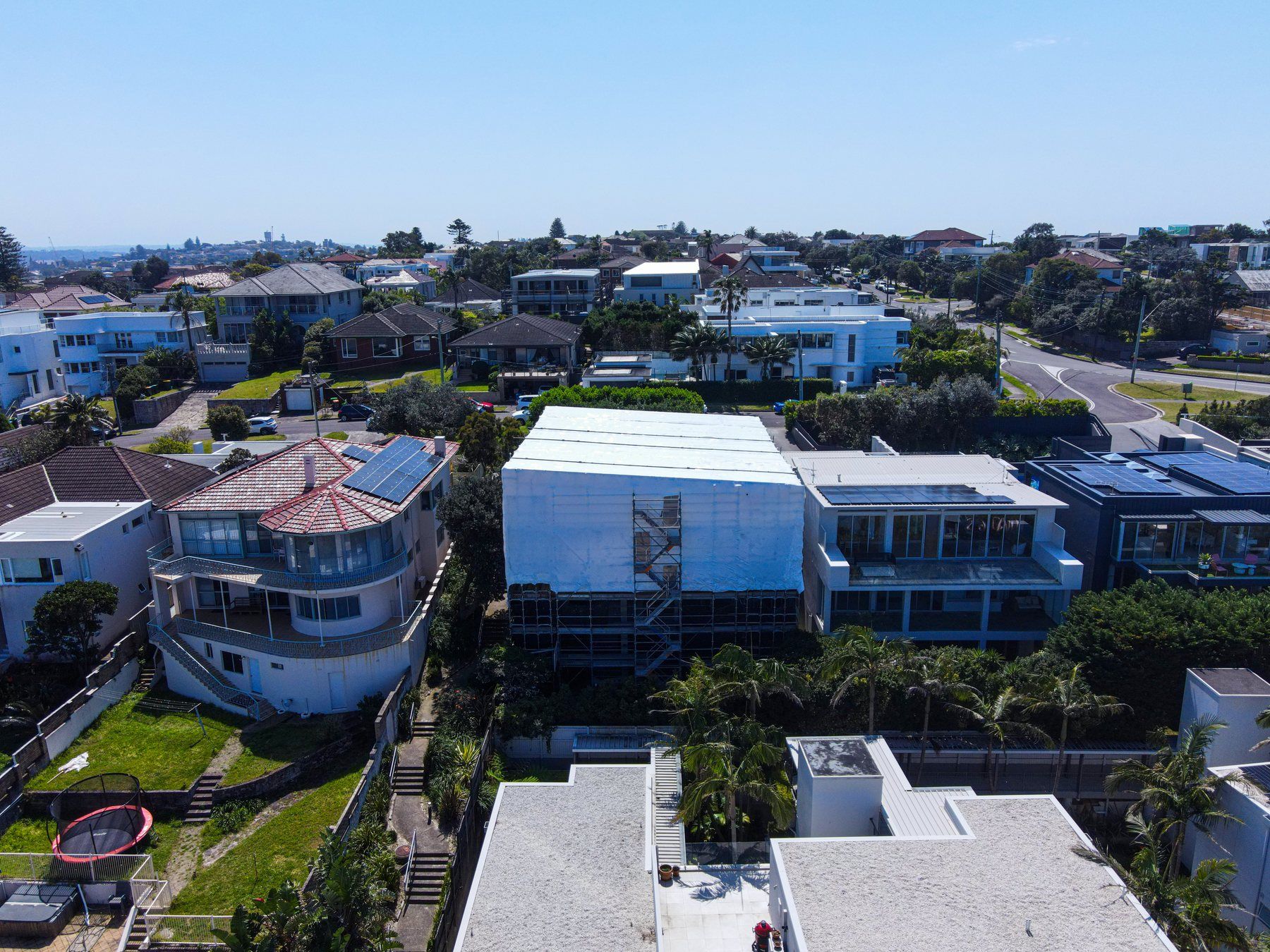 Rear of the wrapped home from the air, the neighbouring houses and their gardens in front