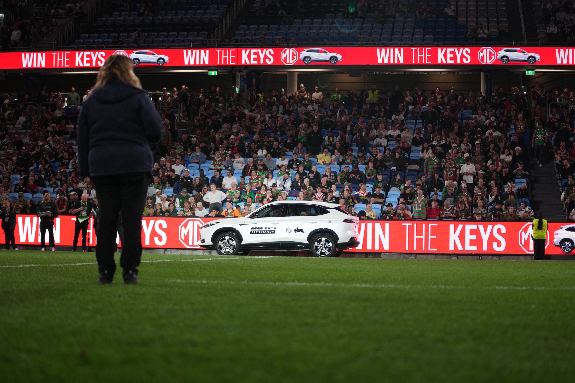 MG HS Hybrid+ branded with the Rabbitohs logo on the field, Win the Keys LED signage behind, Allianz Stadium