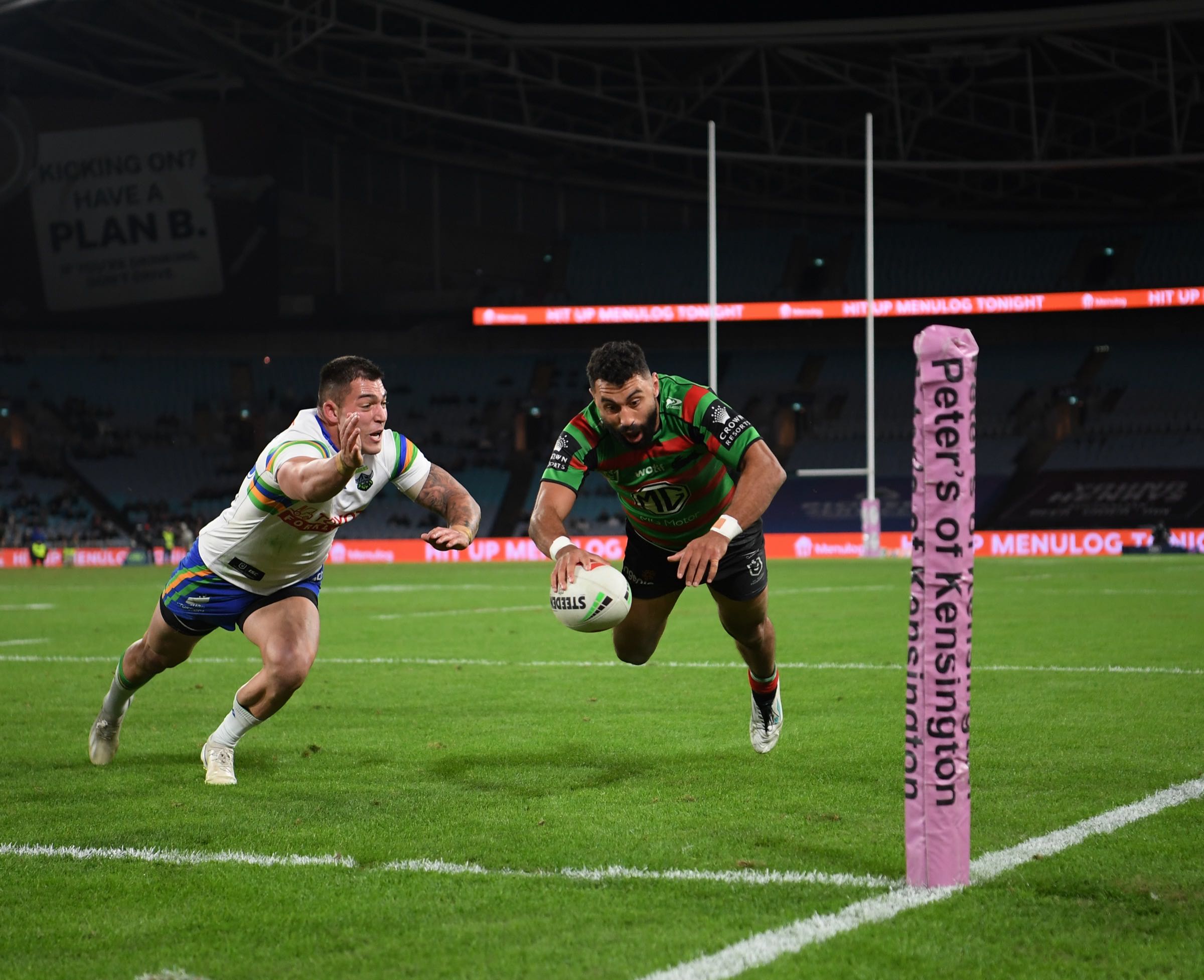 Menulog LED perimeter board visible in the background of a live NRL try-scoring photo